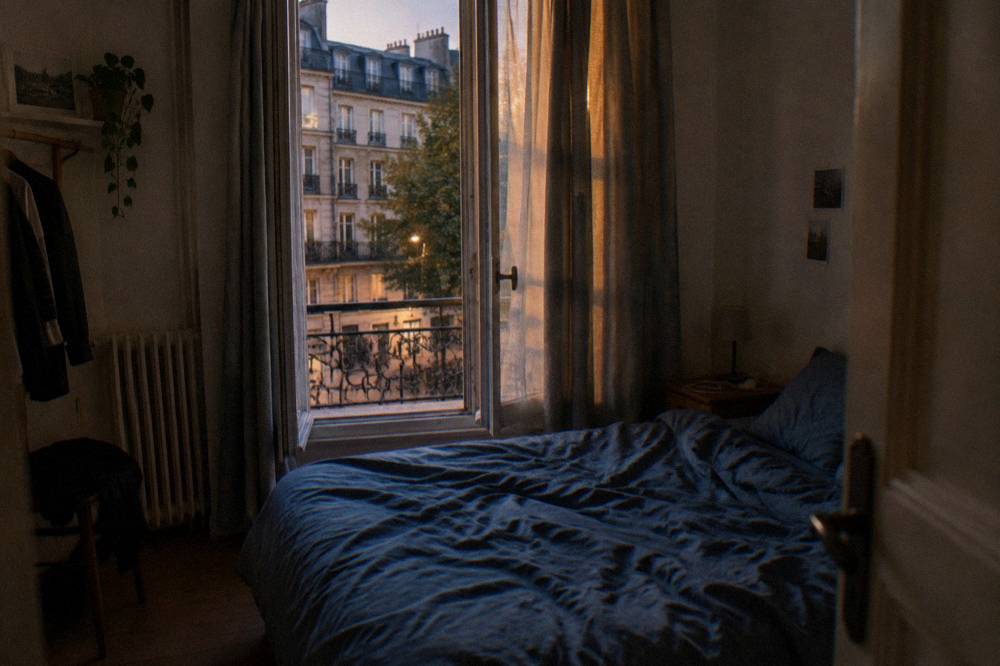 A small budget hotel room in Paris with a double bed and a window onto the street